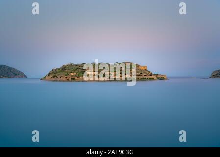 View of the island of Spinalonga with calm sea. Here were isolated lepers, humans with the Hansen's desease, gulf of Elounda, Crete, Greece. Stock Photo