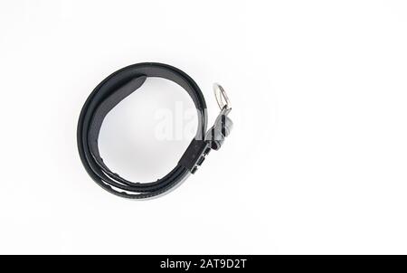 Black belt fashion accessory coiled isolated on a light background.  Leather belt on a light background off centered with room for text. Stock Photo