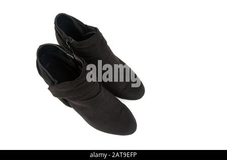 Pair of black heeled boots fashion shoes for women.  Booties are suede and isolated on a light background for footwear of style. Stock Photo