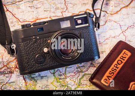 Travel Photography Concept - Photo Camera, Passport and Map on a Dark Wood Background - Vintage Look Stock Photo