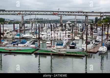 Portland, OR USA June 29, 2016: Bustling marina in Portland is filledwith boat travelers and tourism with one of the bridges over the Willamette river Stock Photo