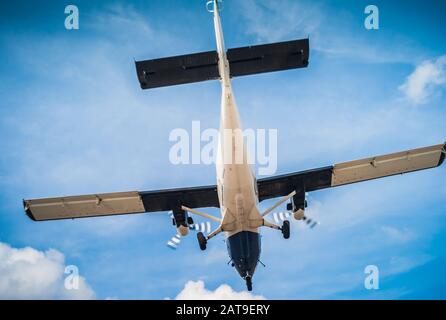 Twin Engine Turbo-Prop Plane Airborne - Flying, Air Travel and Vacation Concept in Blue and White, a Shoulder Wing Propeller Airplane Stock Photo