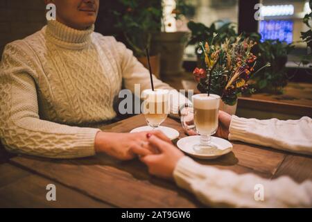 Beautiful couple having coffee on a date,having fun together. Couple young people drinking coffee in stylish modern cafeteria. Couple Resting in Cafe Stock Photo