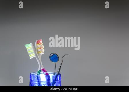 Toothbrushes and dentist set isolated on gray background. Stock Photo