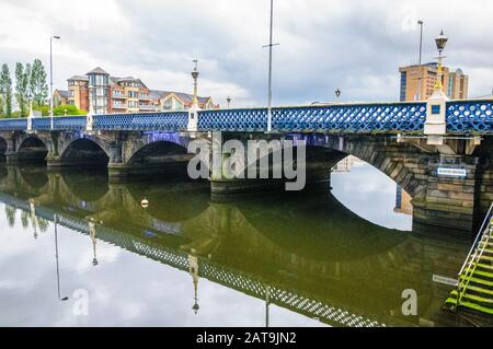 Queen's Bridge over River Lagan in Belfast, Northern Ireland with bridge reflected in the water. Stock Photo