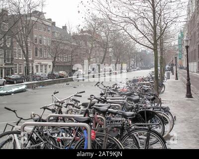 Bicycles along a frozen canal in Amsterdam, Netherlands Stock Photo