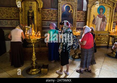 Religious faithful praying within the monastic complex of the Trinity Lavra of St. Sergius in Sergiyev Posad Stock Photo