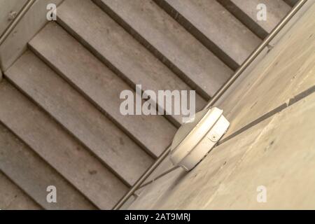 View from above of stairs with metal handrails and round lights on side walls Stock Photo