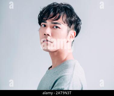portrait of young  asian handsome man isolated on gray background Stock Photo