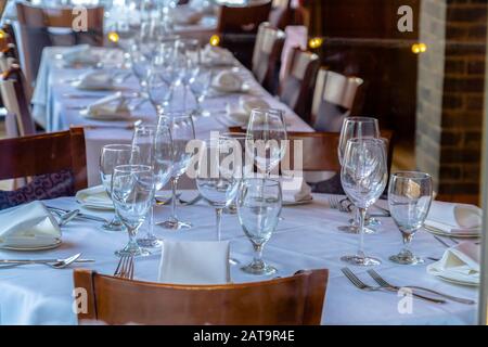 Tableware arranged on round table with white cloth for eating at an occasion Stock Photo