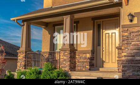 Panorama frame Home with stairs leading to the front door and porch against hill and sky view Stock Photo