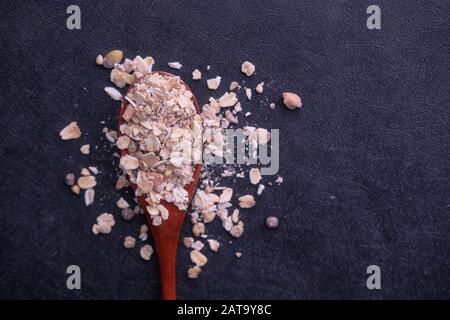 close up of oats on spoon on black background Stock Photo