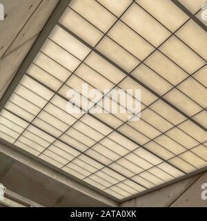 Square Slanting frosted glass roof of a building with round lights on the side walls Stock Photo