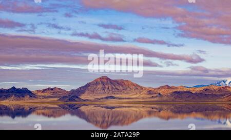 View of mountains in the distance being reflected in the water. View from I-80 rest stop at Utah salt flats covered in water. Stock Photo