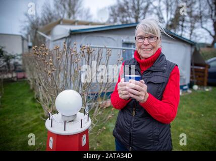 Rerik, Germany. 31st Jan, 2020. Karin Rohland is standing in front of her caravan and awning at the camping park. Alone 26 of the 87 campsites on the Baltic Sea and lakes organised in the state association are also open in Mecklenburg-Western Pomerania in winter. In recent years, the north-east has significantly expanded the range of offers for holidaymakers in the winter months. Between November 2019 and February 2020, around 4.9 million overnight stays were registered, a third more than in the winter of 2009/2010. Credit: Jens Büttner/dpa-Zentralbild/dpa/Alamy Live News Stock Photo