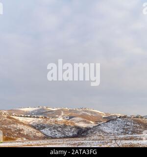 Photo Square Beautiful natural scenery with houses nestled on top of snow covered hills Stock Photo