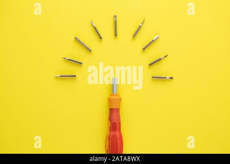 Flat lay of screwdriver with heads on yellow background minimal tool creative concept. Stock Photo