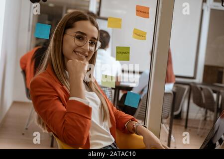 Girl listening to music on laptop as she takes a break from hard work in coworking space. Stock Photo