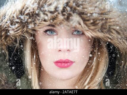 A beautiful girl looks into camera in the snow Stock Photo