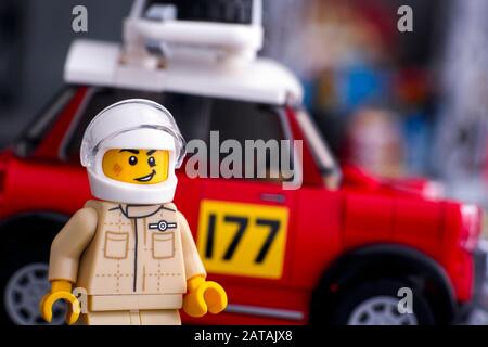 Tambov, Russian Federation - August 18, 2019 Lego 1967 Mini Cooper S Rally driver minifigure by LEGO Speed Champions against his car. Studio shot. Stock Photo