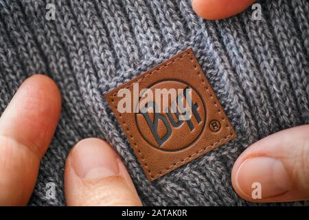 Tambov, Russian Federation - November 16, 2019 Knitted hat with clothes label Buff in woman hands. Close-up. Stock Photo