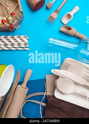 Zero waste concept. Textile brown eco bag, glass bottle, bamboo cutlery and kitchen utensils on blue background with Zero Waste concept. Eco friendly Stock Photo