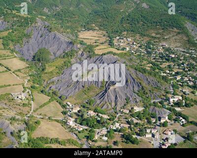 AERIAL VIEW. Village in a landscape of farmlands and badlands. La Robine-sur-Galabre, Alpes de Haute-Provence, France. Stock Photo