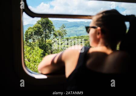 White european female looking through a window on a train in Sri Lanka Stock Photo