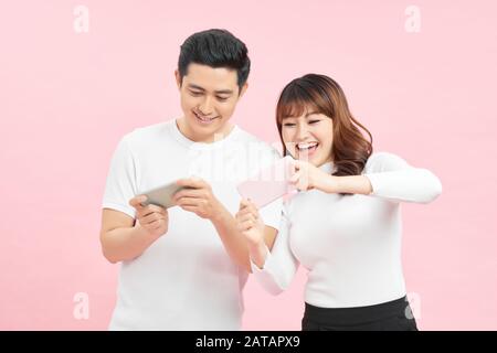 Young couple with mobile phones on color background Stock Photo