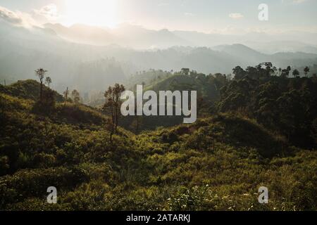 Sun slowly setting behind jungle mountains in Sri Lanka Stock Photo