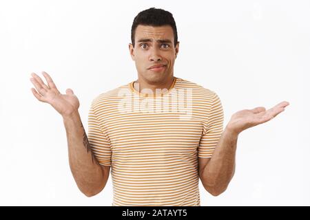 Clueless and confused young perplexed athletic man cant understand anything, shrugging spread hands sideways, smirk problematic, dont know what do, st Stock Photo