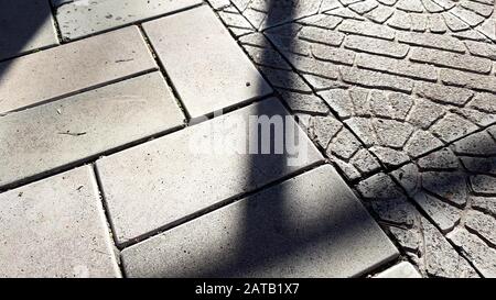 gray stone tiled floor on a sunny street. Stock Photo