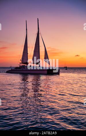 Tourist in the sailboat on the sea at sunset in Key West, Florida. Gulf of Mexico with yachts and sailboats on the vertical background Stock Photo
