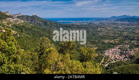 Town of Baunei on left, Triei below, Tortoli and Arbatax at Tyrrhenian Sea coast far in distance, Ogliastra region, Nuoro province, Sardinia, Italy Stock Photo