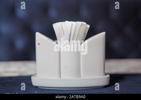 Toothpick. Ceramic pepper pot, salt shaker, toothpicks in paper .disposable wooden toothpicks in individual packing . blurred background in restaurant Stock Photo