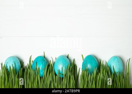 Easter eggs in fresh green grass. On white background Stock Photo