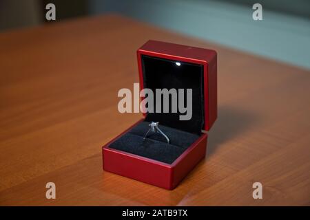 Couple wedding rings in a gift box isolated on wooden background . wedding ring in red box wooden background . Stock Photo