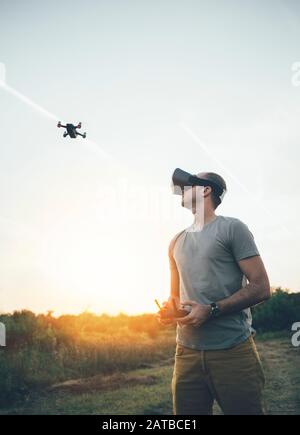 Drone pilot using drone with remote controller and virtual reality headset Stock Photo