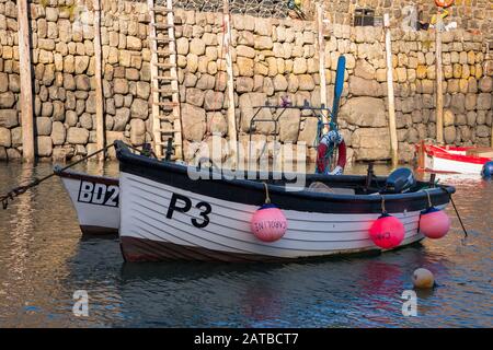 Boats moored at Clovelly harbour in north Devon on a calm sunny morning Stock Photo