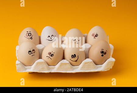 Chicken Eggs With Smileys For Easter Painting on yellow background Stock Photo