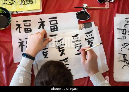A young man learning to write Chinese characters during Calligraphy lesson Stock Photo