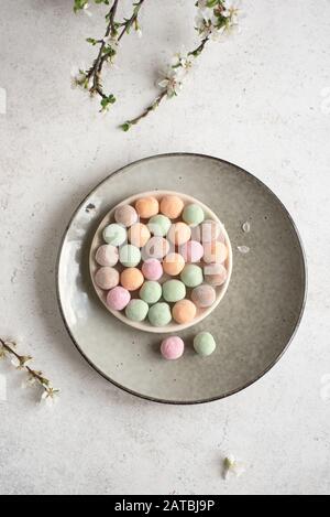 Sweet Japanese Mochi Rice Cakes, colorful moji cakes with spring blossom, top view, copy space. Stock Photo