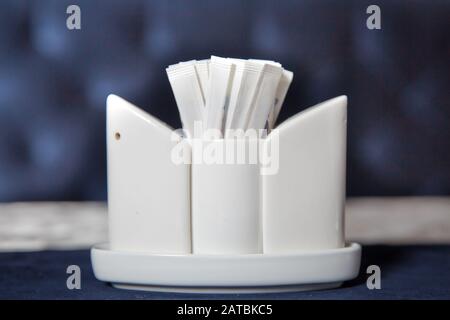 Toothpick. Ceramic pepper pot, salt shaker, toothpicks in paper .disposable wooden toothpicks in individual packing . blurred background in restaurant Stock Photo
