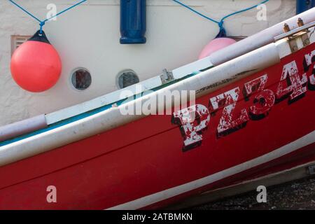 Detail of red rowing boat against white hut with buoy in background Stock Photo
