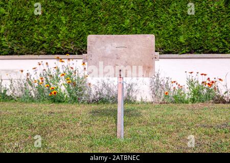 Rectangular stone plate against background of ivy wall. Empty sign board with border, frame. Concept framework, place for text, plate with copy space Stock Photo