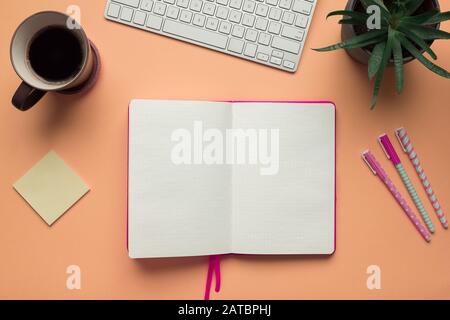 Stock photo of a blank open notebook page in the middle of office desk table Stock Photo