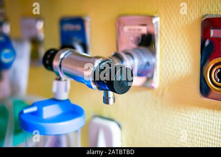 Rotary pressure regulator with valve in a hospital room connected to a wall-mounted connector Stock Photo