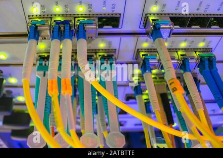 Data center. A lot of optical links are lit on the front panel of the central Internet router. Fiber-optic wires are connected to the central server Stock Photo