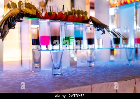 collection of colorful shots with fruits on bar. set of alcohol mini cocktail shooters. Stock Photo