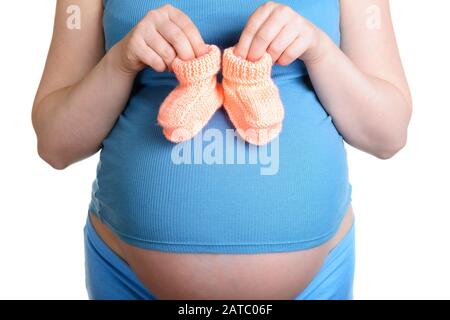 Pregnant woman holding a beautiful woolen baby shoes isolated on white Stock Photo